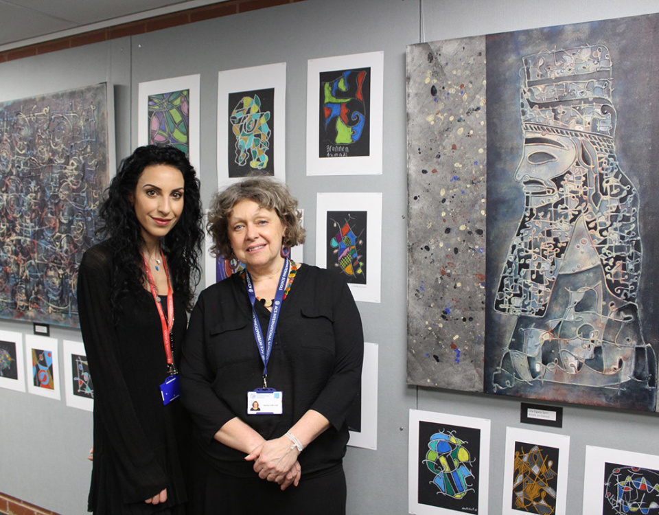 Lina Ogaily and ACS Hillingdon instructor standing in front of Lina's artwork